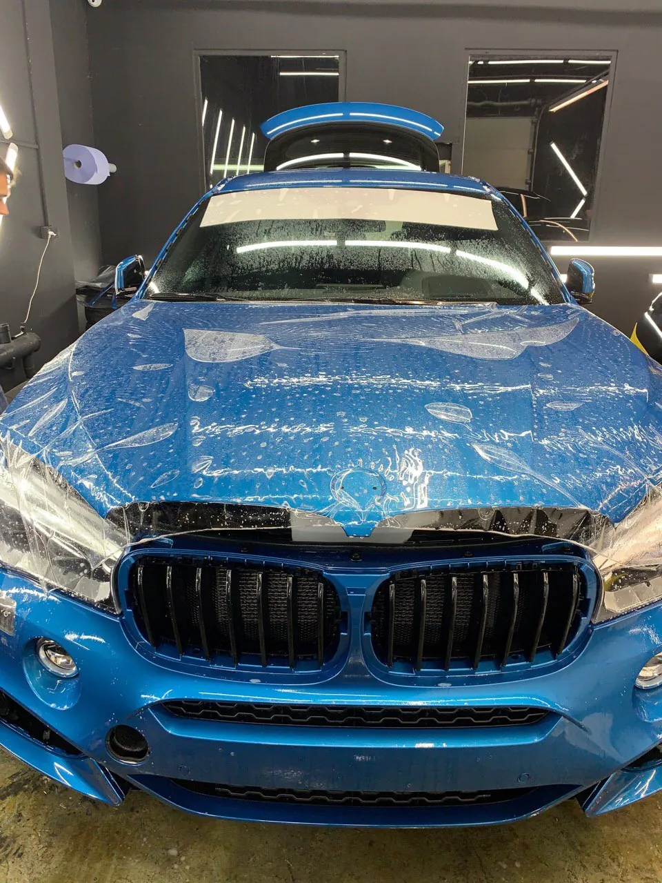 Нанесение защитной плёнки на капот синего BMW